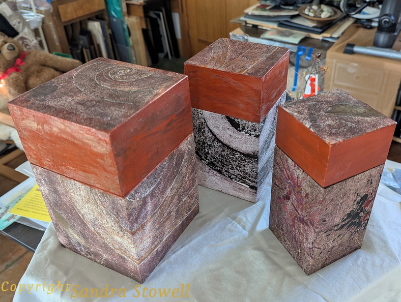 Three wooden nesting boxes acquired, then wrapped in art. I wrapped these boxes and the led tops with mixed media monoprints, and & painted the top sides. Some sanding, and alot of careful cutting & applying, finessing the edges, etc. These are sealed with clear acrylic medium, but a bit delicate! ThreeNestingBoxes2.jpg