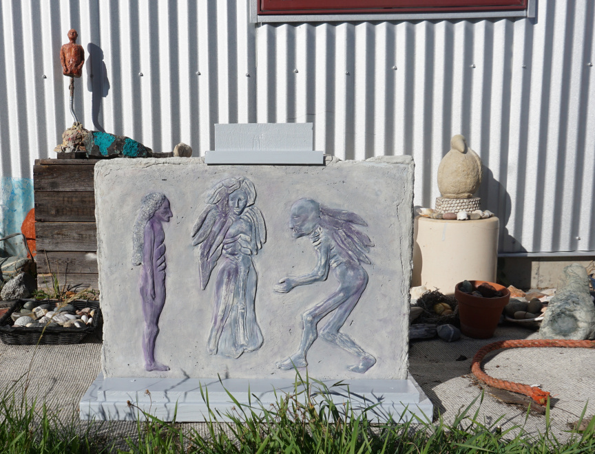 Photo of relief cement cast of Three Angels: The Mediation in wooden stand outside my Studio