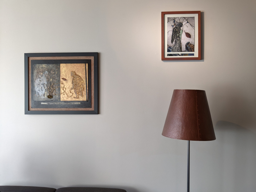 Photo of two artworks hung over a sofa